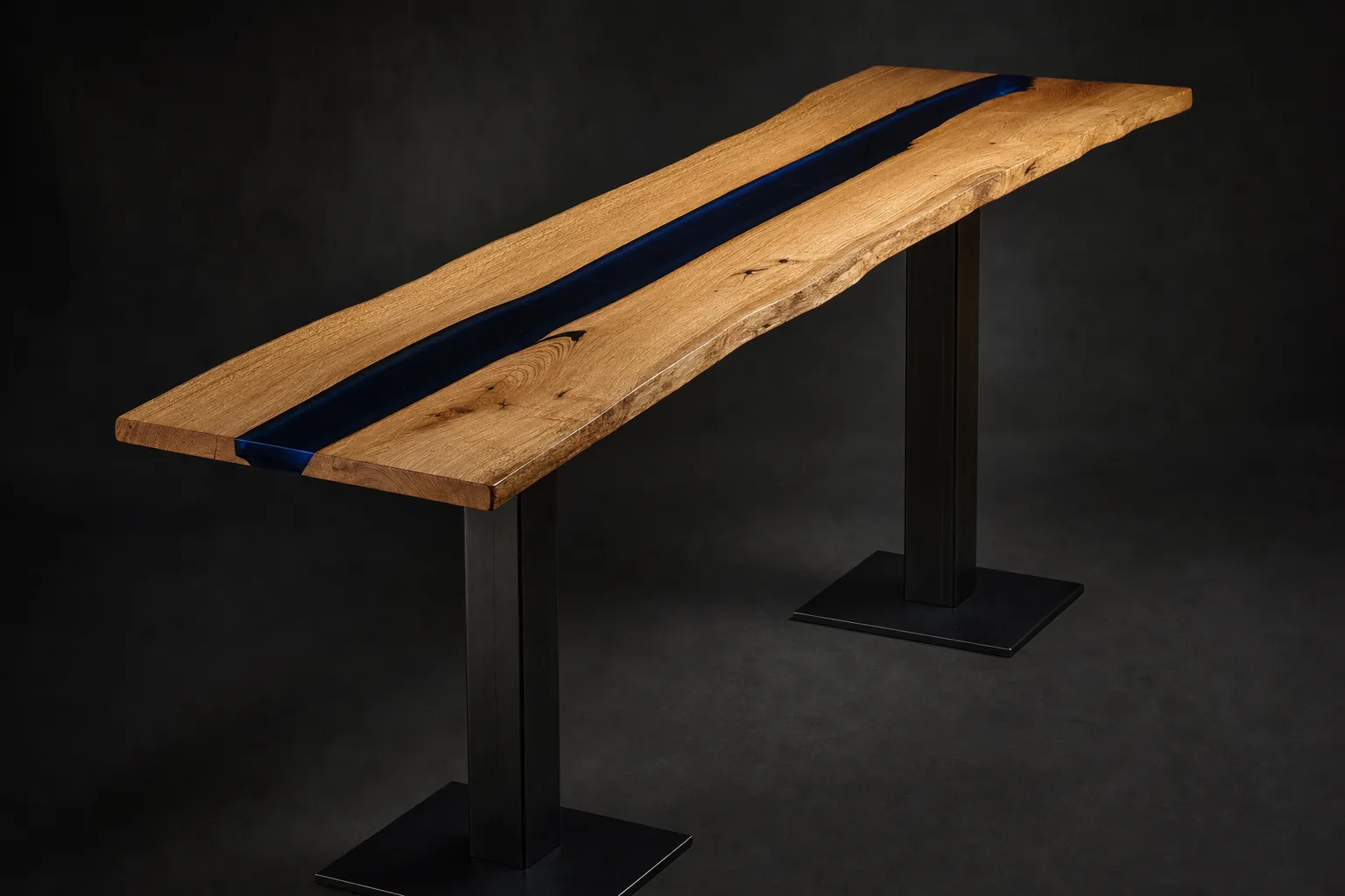 Headwater bar table, three-quarter view: tall narrow Oregon white oak slab with a deep navy resin channel, paired blackened steel column base